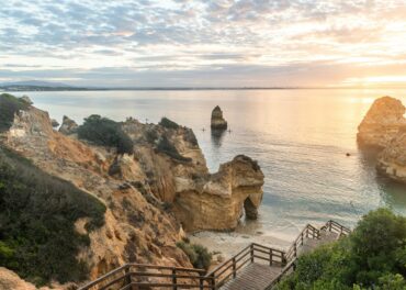 Wooden footbridge to beautiful beach Praia do Camilo near Lagos in Portugal at sunrise