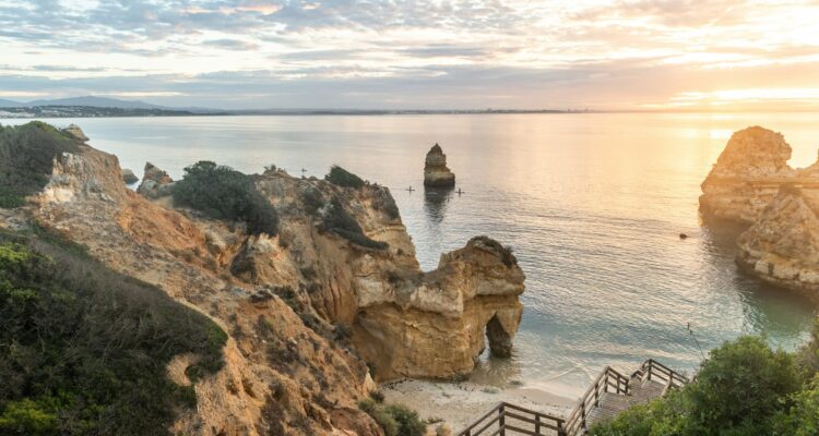 Wooden footbridge to beautiful beach Praia do Camilo near Lagos in Portugal at sunrise