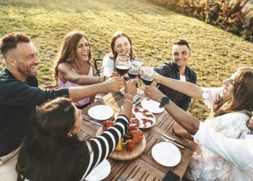 Group of friends having fun at bbq outside dinner in home garden